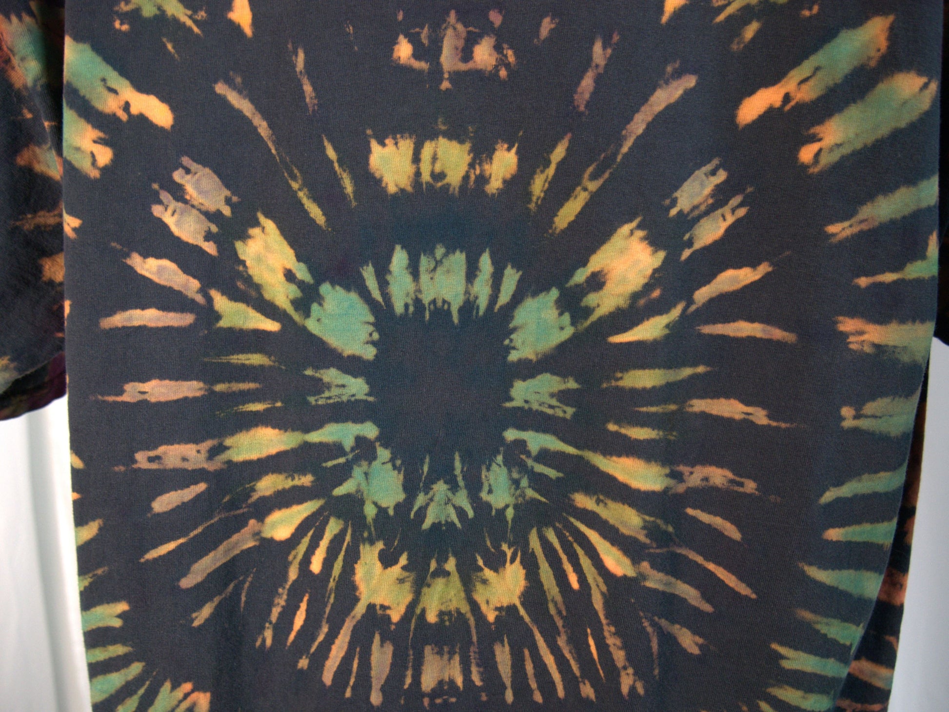 Ocular Reverse Tie Dye T Shirt using a Spiral Design in Green, Orange and Black, in size Large, showing back detail of shirt