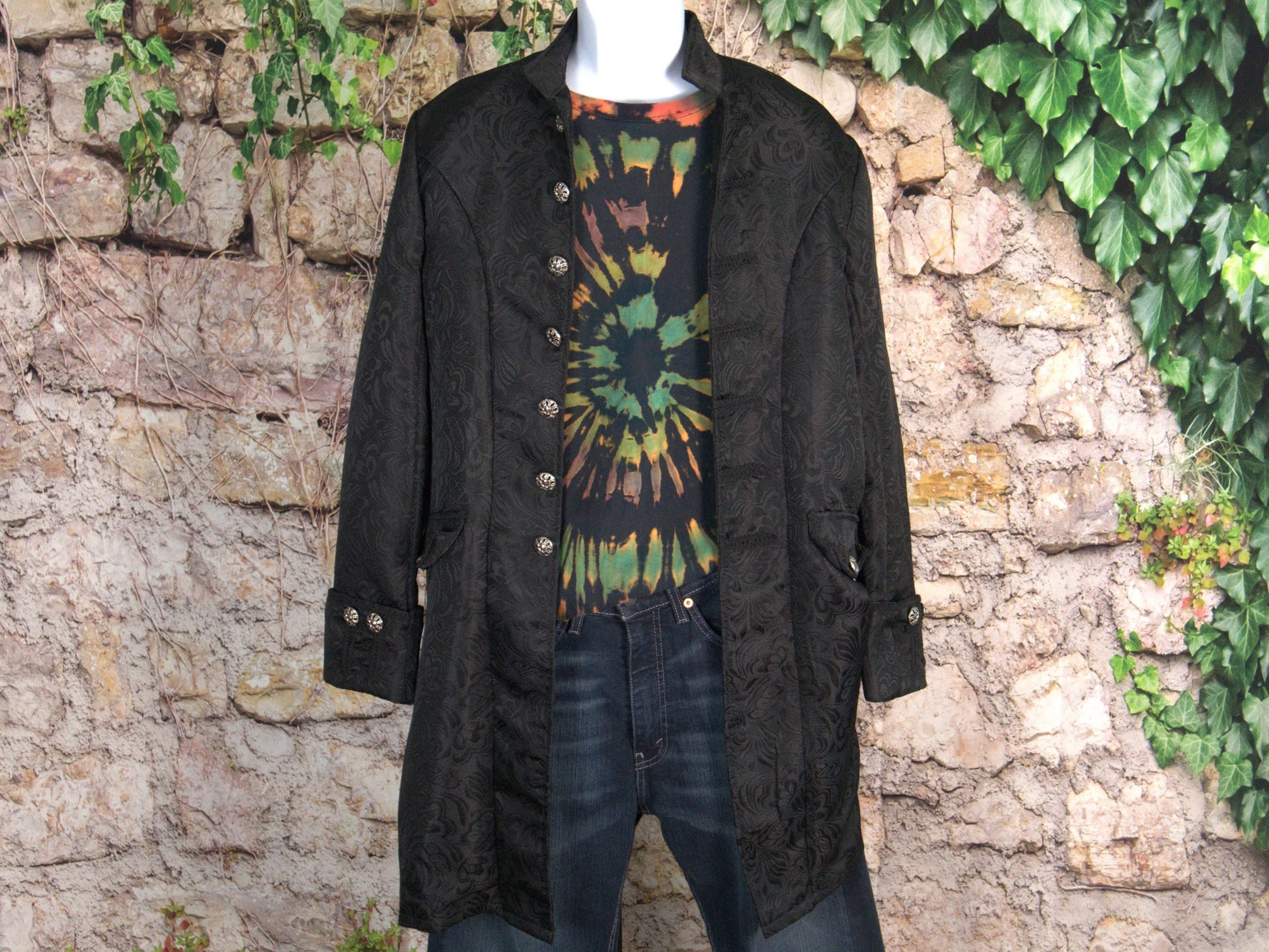 Ocular Reverse Tie Dye T Shirt using a Spiral Design in Green, Orange and Black, in size Large, styled with a military style jacket and jeans