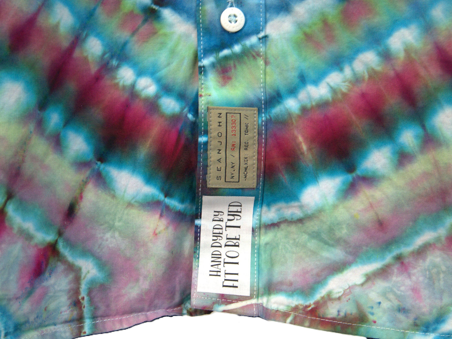Turquoise, Red and Blue short sleeve tie dye button down dress shirt in an experimental style, showing front label detail