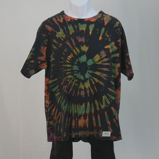 Ocular Reverse Tie Dye T Shirt using a Spiral Design in Green, Orange and Black, in size Large, video of shirt spinning